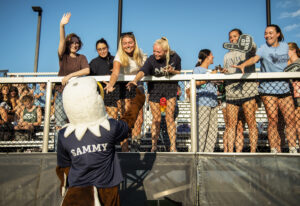 Sammy D. Eagle mingles with fans at a UMW women’s field hockey game. Happening this week, UMW Homecoming features an array of events and athletic competitions.