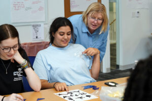 Professor of Education Teresa Coffman works with a high school student from Prince William County during a recent field trip for Teachers for Tomorrow participants to UMW's Seacobeck Hall, home to the College of Education. Photo by Suzanne Carr Rossi.