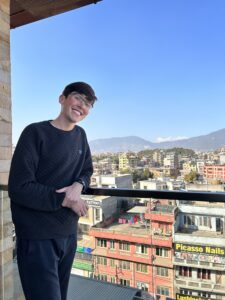 Francis in Kathmandu, Nepal, with the Himalayan mountain range in the distance during the UMW in Nepal, international perspectives of civic engagement trip.