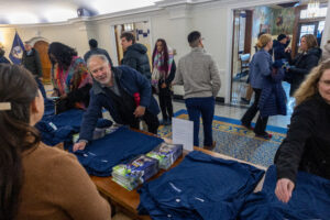 Assistant Professor of Painting and Drawing Ashe Laughlin picks up a polo shirt with the new UMW logo before heading into President Paino's start-of-the-semester address for faculty and staff. Photo by Sam Cahill.