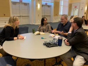 Sarah Rose Cavanagh (far left), author of 'Mind Over Monsters: Supporting Youth Mental Health With Compassionate Challenge,' talks with faculty members, including College of Arts and Sciences Dean Keith Mellinger (far right) in UMW's Chandler Ballroom.