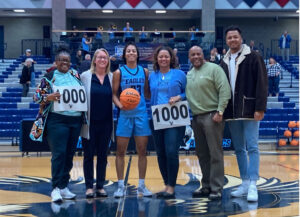 Carpenter (third from left) poses with women's basketball coach Deena Applebury (second from left) and loyal supporters at UMW's Anderson Center after the buzzer-beating game that landed her in the 1,000-point club.