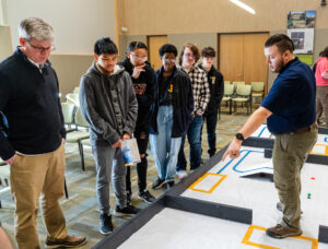 The Naval Surface Warfare Center Dahlgren Division's Michael Darnell confers with members of the James Monroe High School team. Photo by Dave Ellis.
