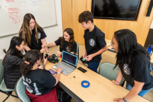 Ayla Zook (fourth from left, sitting) works with her teammates at UMW's Dahlgren Campus during the third annual High School Innovation Challenge @ Dahlgren. The team, from King George County High School took top prize, claiming $3,500 for STEM learning at their school. Photo by Dave Ellis.