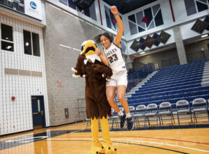Jordan Carpenter shows off her moves on the court with UMW mascot Sammy D. Eagle.