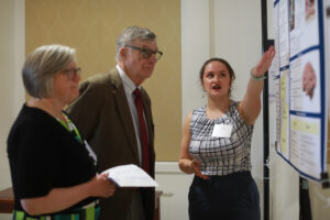 Senior Sofia Taylor shares her research into the minds of the world's great composers with Bill Williams and Pat Poole at the 2024 Donor Appreciation Luncheon and Student Showcase. The annual event, for which Taylor served as emcee, honors donors who have established or supported scholarships for students and those who have given or pledged significant gifts to the University of Mary Washington. Photo by Karen Pearlman.