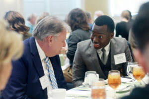 Sophomore Aloysious Kabonge, who received the Thomas Howard and Elizabeth Merchent Tardy Scholarship, among others, chats during lunch with his donor, Al Merchent. Photo by Karen Pearlman.