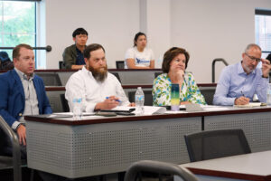 The four judges in this year's Case Competition for business students include, from left to right, Andrew Blate '04, his business partner Craig Schneibolk, Linda Blakemore '84 and Lou Marmo '94. The juges deliver comments in 'Shark Tank'-style ... but nicer. Photo by Suzanne Carr Rossi.