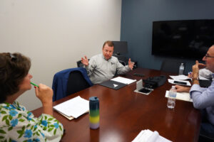 From left to right: Case Competition judges and UMW alumni Linda Blakemore '84, Andrew Blate '04 and Lou Marmo '94 deliberate in a secluded room following the Case Competition presentations. Photo by Suzanne Carr Rossi.