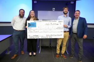 From left to right: Craig Schneibolk, UMW students Jenna Diehl and Brian Gaydos and Andrew Blate '04 pose with the winning check at the end of last week's Case Competition for business students. Diehl and Gaydos won the competition, judged by Schneibolk and Blate, who sponsor it, along with two other judges. Photo by Suzanne Carr Rossi.