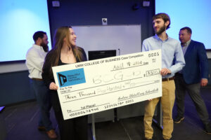 UMW business students Jenna Diehl and Brian Gaydos show off their first-place prize - a check for $3,500 - during the College of Business Case Competition. The judges said they were impressed by the pair's answering of their questions, presentation of a timeline and current financial analysis. Photo by Suzanne Carr Rossi.