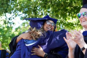 Faculty members line up on either side of Campus Walk to cheer on the graduates. Photo by Suzanne Carr Rossi.