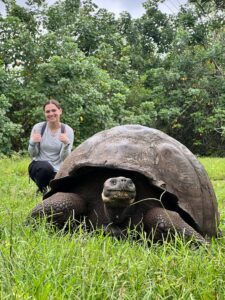Brunt received the Sally Brannan Hurt '92 Study Abroad Scholarship in Biology, which gave her the opportunity to travel to the Galápagos Islands to study the flora and fauna of one of the most biodiverse places on the planet. Here, she poses for a photo with a Galápagos tortoise at an ecological reserve, El Chato Ranch, on the island of Isabela. Photo courtesy of Madeline Brunt.