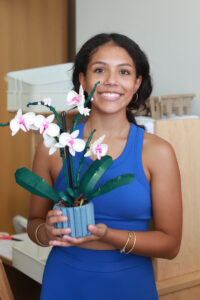 UMW first-year student Victoria Arozco of Arlington, Virginia, poses with the Lego orchids she brought from home to brighten her Randolph Hall room. Photo by Karen Pearlman.