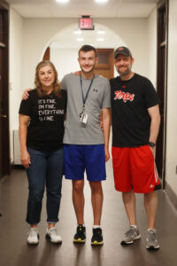 Ethan Wilbur (center) poses with his parents in Virginia Hall. His mom, Sarah, wore her emotions on her shirt, bought especially for Mary Washington Move-In Day. Photo by Karen Pearlman.