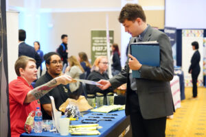 Students exchanged resumes for job information at UMW's recent Career and Internship Fair, held in the Cedric Rucker University Center's Chandler Ballroom. Photo by Suzanne Carr Rossi.