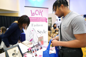 UMW sophomore Trey Nix, an accounting major, stops to inquire at the LOK Fashion Academy's table at the Career and Internship Fair. The Stafford County fashion institute was one of 45 employers who came to the fair looking for students to hire. Photo by Suzanne Carr Rossi.