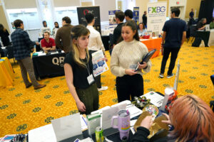 UMW students Ava Shumate (left) and Sarah Eltablyhi peruse the recent Career and Internship Fair, held in the Cedric Rucker University Center's Chandler Ballroom. Forty-five local and regional employers attended, along with hundreds of students. Photo by Suzanne Carr Rossi.