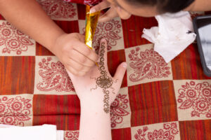 A fairgoer gets a traditional henna tattoo applied in many cultures using natural dye for special celebrations.