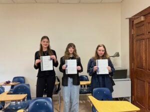 UMW students (from L) junior Dinah McKemie, sophomore Emma Greer and first-year student Elena Shipp pose with awards received on the National Latin Exam.