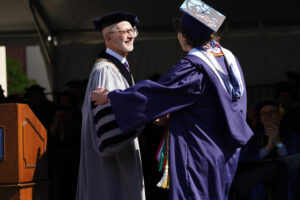 Class President Shadwick Yoder shakes hands with Mary Washington President Troy Paino after speaking to his fellow graduates from the podium.