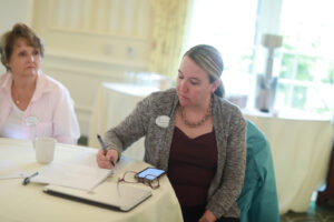 Alumni Board member Colette Strawn Johnson ’97 (right) takes notes during the Fund for Mary Washington Impact Grant presentations while Alumni Board member Jennifer Boyd Ross ’79 looks on. Photo by Karen Pearlman.
