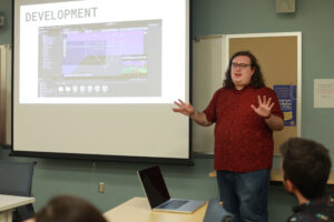 Senior music major Nathaniel Harvey helps his team present their year-end project on audio design for video games. Photo by Karen Pearlman.