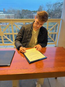 Thompson signs a bill as Student Government Association president. He took a chance, he said, by running for office but believed he could make a difference at Mary Washington in the top student government role.