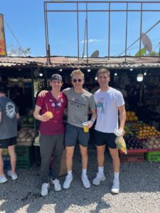 Thompson (left) poses with his best friends and roommates, Atlan Murray and Carter Berg. Here, the friends pose for a photo while visiting a local market during a trip to play soccer with the UMW team in Costa Rica.