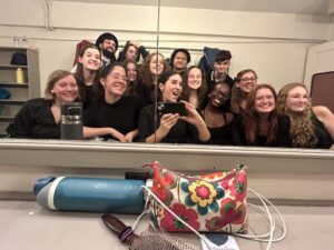 Brianna Kenealy (pictured upper right of the woman holding the iPhone) served as vice president and president of the UMW a cappella group Symfonics.