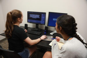 UMW seniors Nyah Speicher (left) and Avery Gallahue, seen here in Mercer Hall's Eye Tracking Lab, were part of a four-student group who conducted research with guidance from Professor of Psychological Science Marcus Leppanen during this year's AHSSSI. Photo by Karen Pearlman.