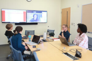 From left: UMW sophomore Cory Wagaman-Eure, junior Kenzie Lotz, Professor of Communication and Digital Studies Zach Whalen and senior Asunta Ross speak virtually with a consultant while working on their AHSSSI project, 'Experiments in Generative AI, Literature and Machine Learning for Creative Writing.' Photo by Karen Pearlman.