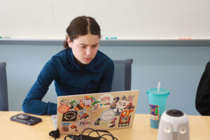 UMW junior Kenzie Lotz works on her team project during this year's AHSSSI. The group paired AI-training frameworks like Unsloth and Ollama with classics like 'A Christmas Carol' and 'Uncle Tom’s Cabin' to see how well AI could pick up on specific writing styles. Photo by Karen Pearlman.