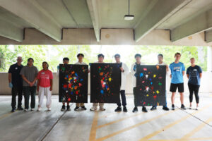 Participants in the PING program show off their paintball splatters, reminiscent of evolving stellar clusters. From left: UMW Physics Chair and Professor Matt Fleenor; UMW mentor Aliya Ather ’28; volunteer mentor Emma Wallach, a Stafford High School junior who participated in the PING program at MSU; high schoolers Alexander Rosas, Vincent Phan, Tristan Towle, Zubair Mohammadzai, Michael Young and Maiwand Barakzai; and UMW mentors CJ Hulleman ’28 and Hannah Steele ’26. Photo by K Pearlman Photography.
