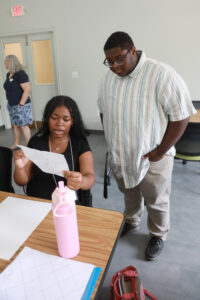 Germanna Community College student C.J. Hall helps out in Professor of Mathematics Debra Hydorn's Summer Enrichment Program course, The Art of Mathematics. Hall, who hopes to teach math himself, was able to shadow Hydorn during the weeklong summer session thanks to UMW's Noyce Scholars Program for students who hope to teach in STEM-related fields. Photo by K Pearlman Photography.