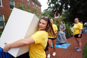 A UMW upperclassman helps a family transfer a new student's belongings from their car to a residence hall room. More than 100 students signed up as volunteers during Move-In Day 2025. Photo by Suzanne Carr Rossi.