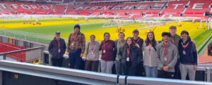 A UMW study-abroad group poses at Old Trafford Stadium, home of the Manchester United Football Club in England in 2024. The spring break trip is one of many that students can learn about at UMW's Global Cafe and Education Abroad Fair events this fall.