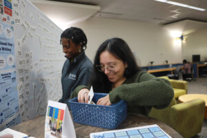 History and secondary education majors Ashley Palin (L) and Lesley Morales-Sanchez (R) take a break from studying to create magnetic poetry in the Simpson Library. Photo by Karen Pearlman.