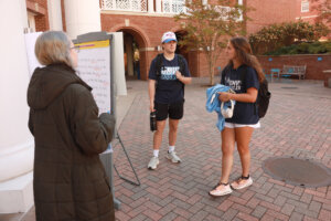 Participants tried Mad Libs outside the Hurley Convergence Center assisted by Morgan Zimmerman (L), a senior biochemistry and studio art double major that works as a student consultant for the Speaking and Writing Center. Photo by Karen Pearlman.