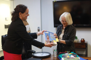 Juliette Landphair (left), associate vice president for health and well-being at Mary Washington, shows Betty Talley a copy of Princeton Review's 'The Best 391 Colleges' guide for 2026, which lists Mary Washington at #15 Best Student Support and Counseling Services. Photo by K Pearlman Photography.