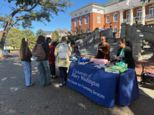 Talley Center staff Amira Niori (right), Jimmy Nguyen (left) and Debbie Huff (not pictured), along with Marissa Miller (center), director of UMW's Center for Prevention and Education, hand out cookies and sandwiches on Campus Walk during Talley Treats. Held on Thursdays throughout October, the initiative promotes well-being and connection at a point in the semester that can feel overwhelming to students. Local vendors, including several alumni, provide the treats and gift cards for raffles.