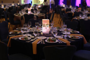 Table set for eight with a lantern in the middle featuring top rankings from college guides.