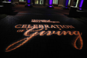 University of Mary Washington Celebration of Giving in lights on the bricks in front of the Cedric Rucker University Center at night.