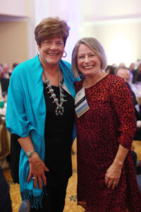 A party guest, Linda Coker, with Kelly Paino, wife of President Troy Paino.