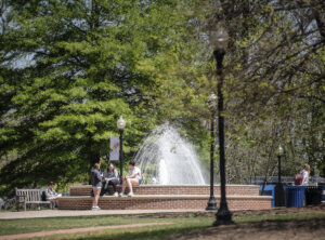 Photo of two UMW students in front of a fountain and greenery on campus.