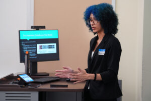 UMW junior Kassandra Williams explains her research – 'Convolutional Networks for Determining Optimal Block Preconditioners' – during an oral presentation for the Network of Undergraduate Research in Virginia Conference. Completed with Assistant Professor of Computer Science Evan Coleman, the study aims to break enormous equations into understandable bits, using computational guesswork to home in on an actual answer. Photo by Suzanne Carr Rossi.