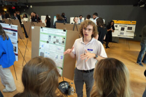 Longwood junior biology major Jackson (Jay) Geeslin explains the poster representing his study – 'Impacts of Polyethylene on Batrachochytrium Dendrobatidis' – at the Network for Undergraduate Research in Virginia Conference at UMW. His work explores the effects of environmental pathogens on an aquatic fungus that adheres to amphibians. Photo by Suzanne Carr Rossi.