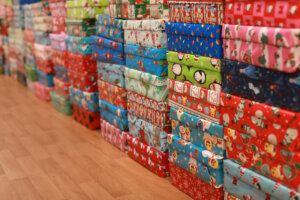 Stacks of wrapped gift boxes arranged inside the Walker-Grant Center for delivery to Fredericksburg preschool classrooms.
