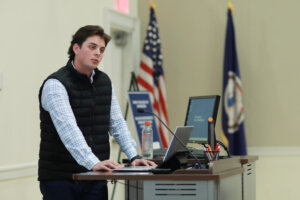 A UMW student stands, listening to judges' feedback during the Case Competition