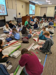 UMW student volunteers on the floor wrapping the gift boxes that get delivered to local preschool students.